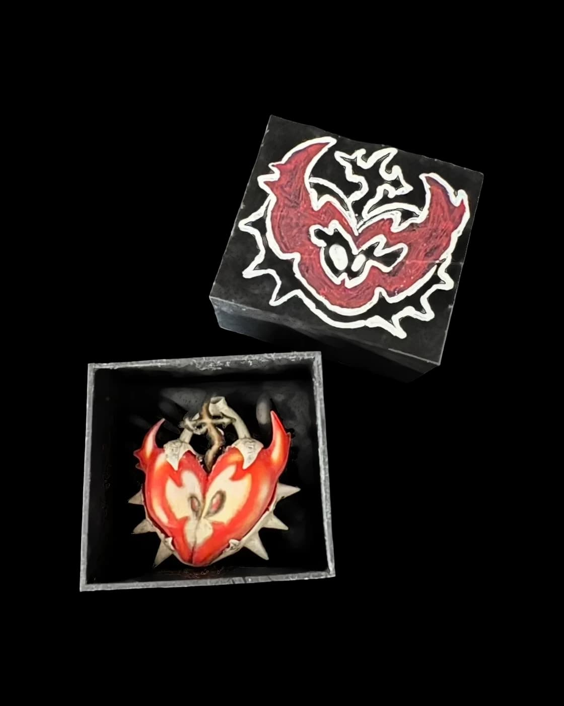 Two clubstar.haus pins in their boxes, a dragon and a burning heart