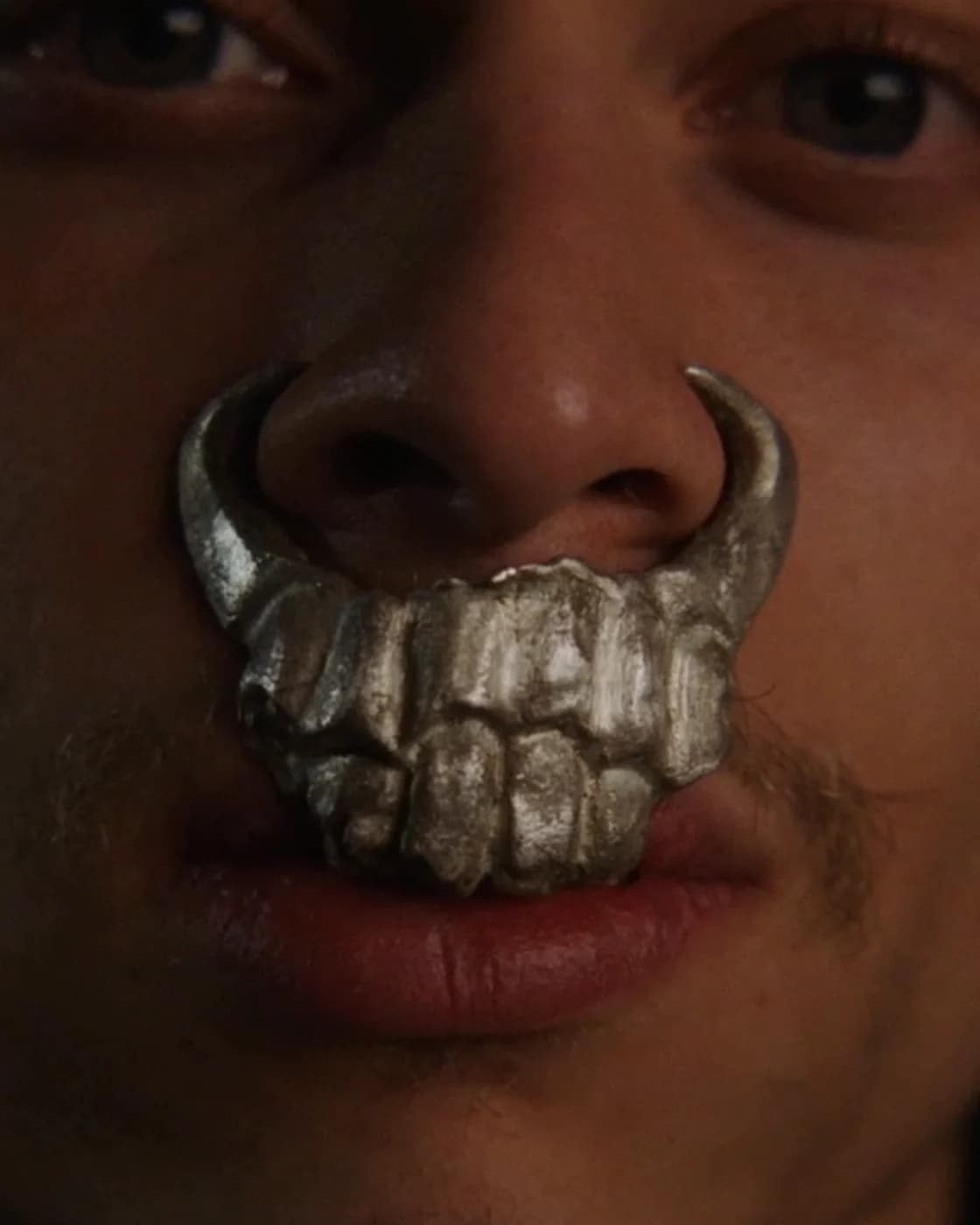 Clubware I worn: cast metal teeth with two tusks curving up across the nose and upper lip