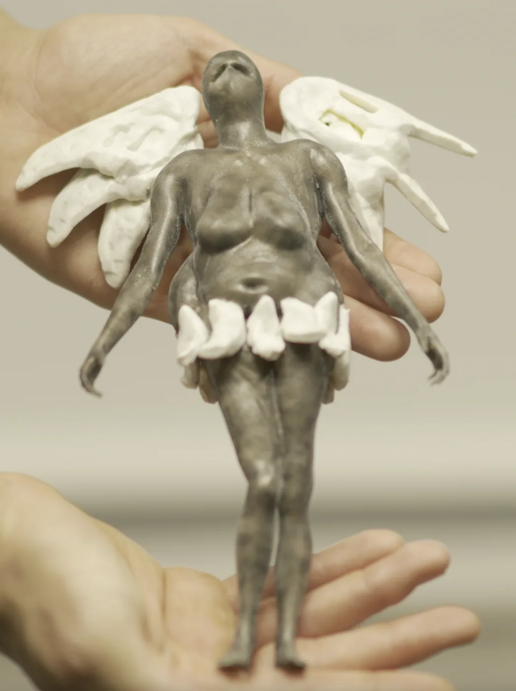 Club Karma, the winged figure, held in two hands