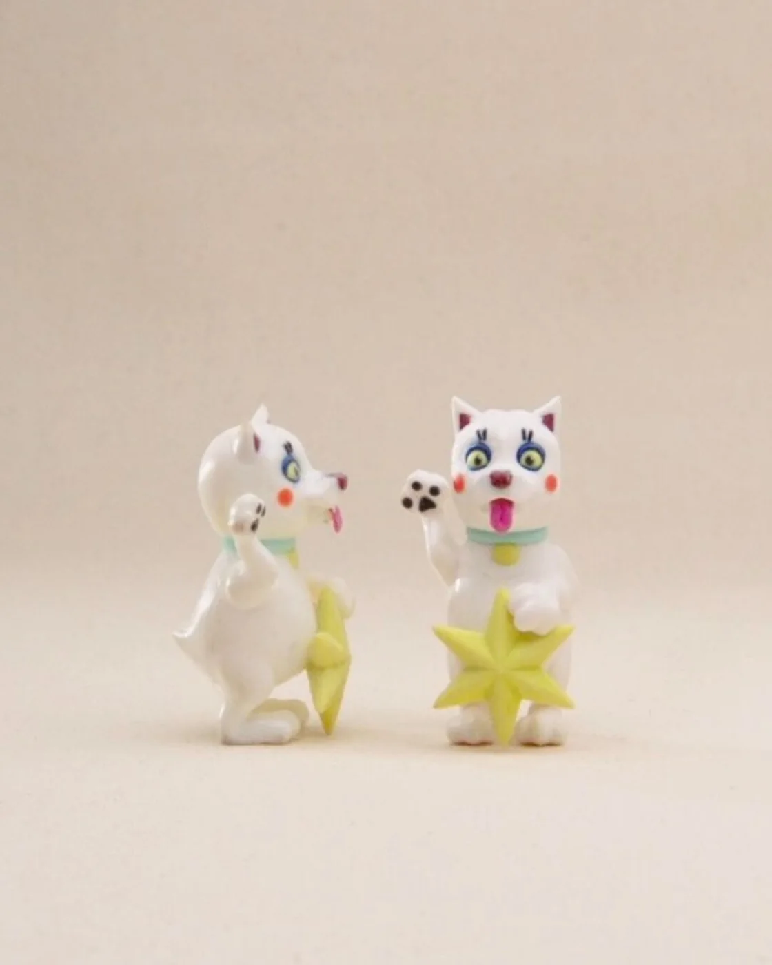 Two Lucky Dog figures, glazed white with yellow stars