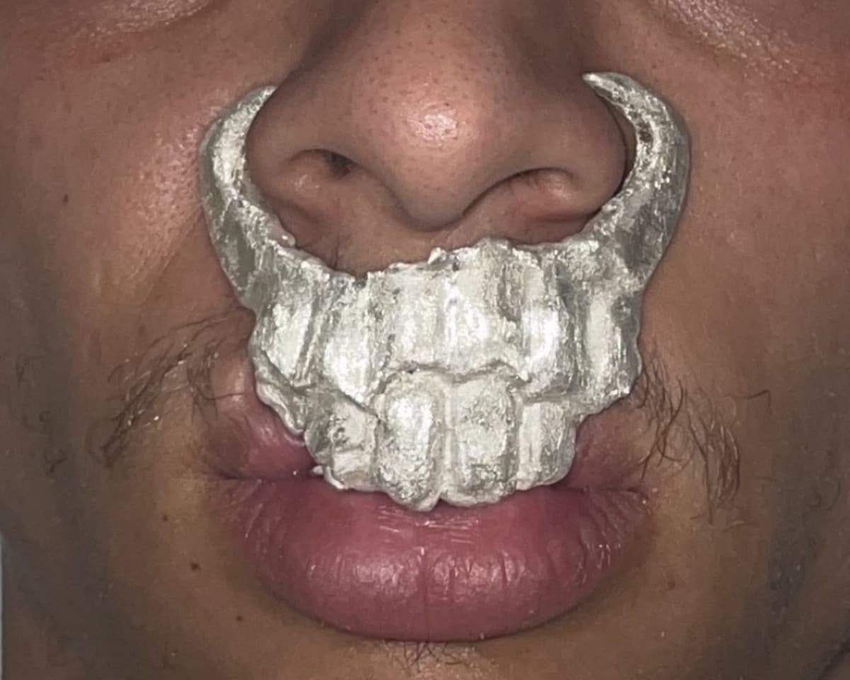 Clubware worn over the mouth and under the nose, cast silver taking the shape of the teeth beneath it.